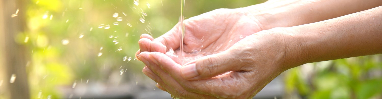23454769 Water Pouring In Woman Hand On Nature Background